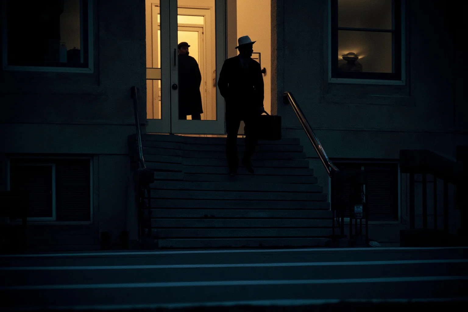 A 1940s Washington D.C. government building exterior at dusk with a shadowy figure carrying a briefcase down the steps