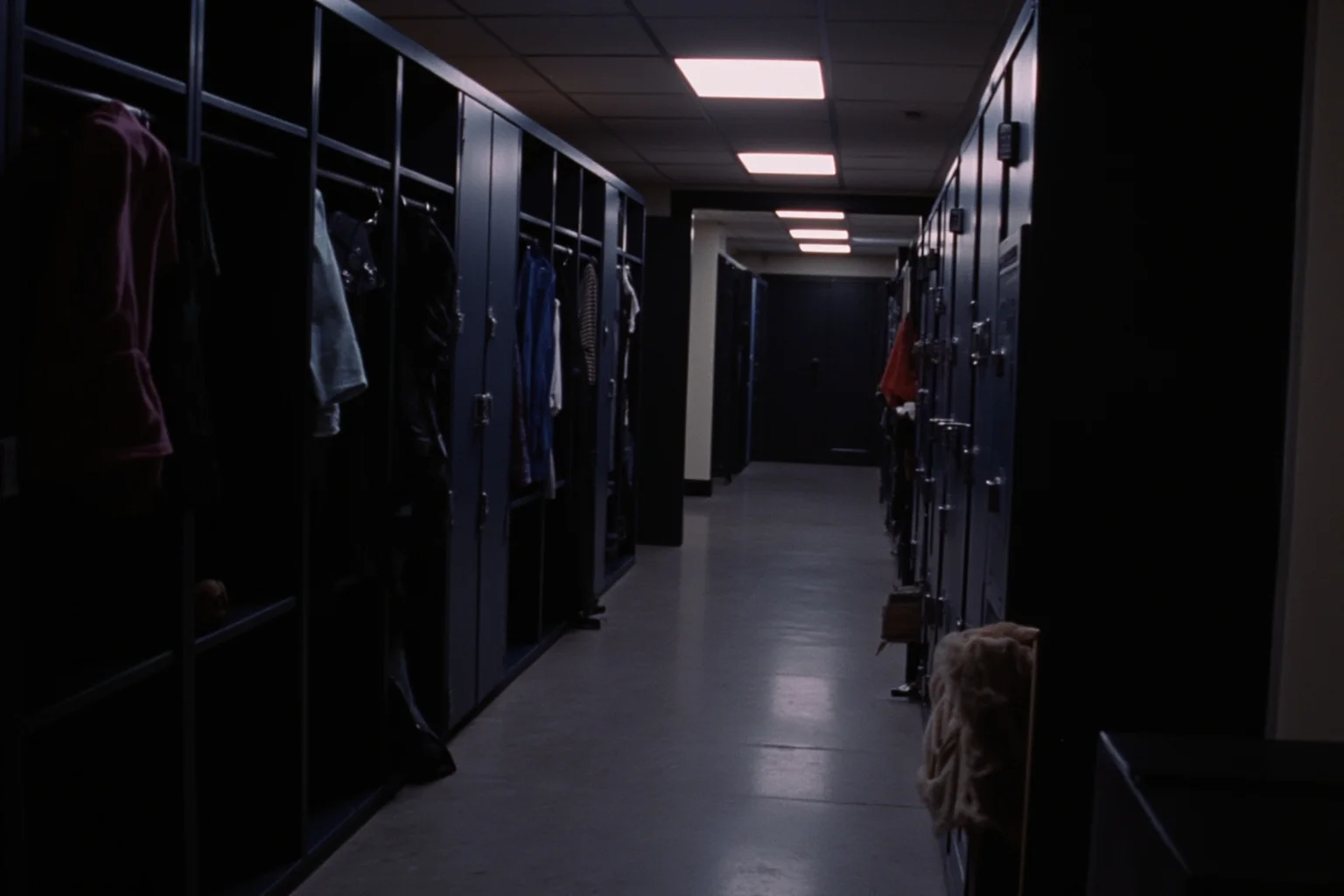 22 Hollywood Stars Whose Lives Ended in Tragedy 10 A 1980s SNL-style backstage hallway with lockers and costume racks, dimly lit and quiet