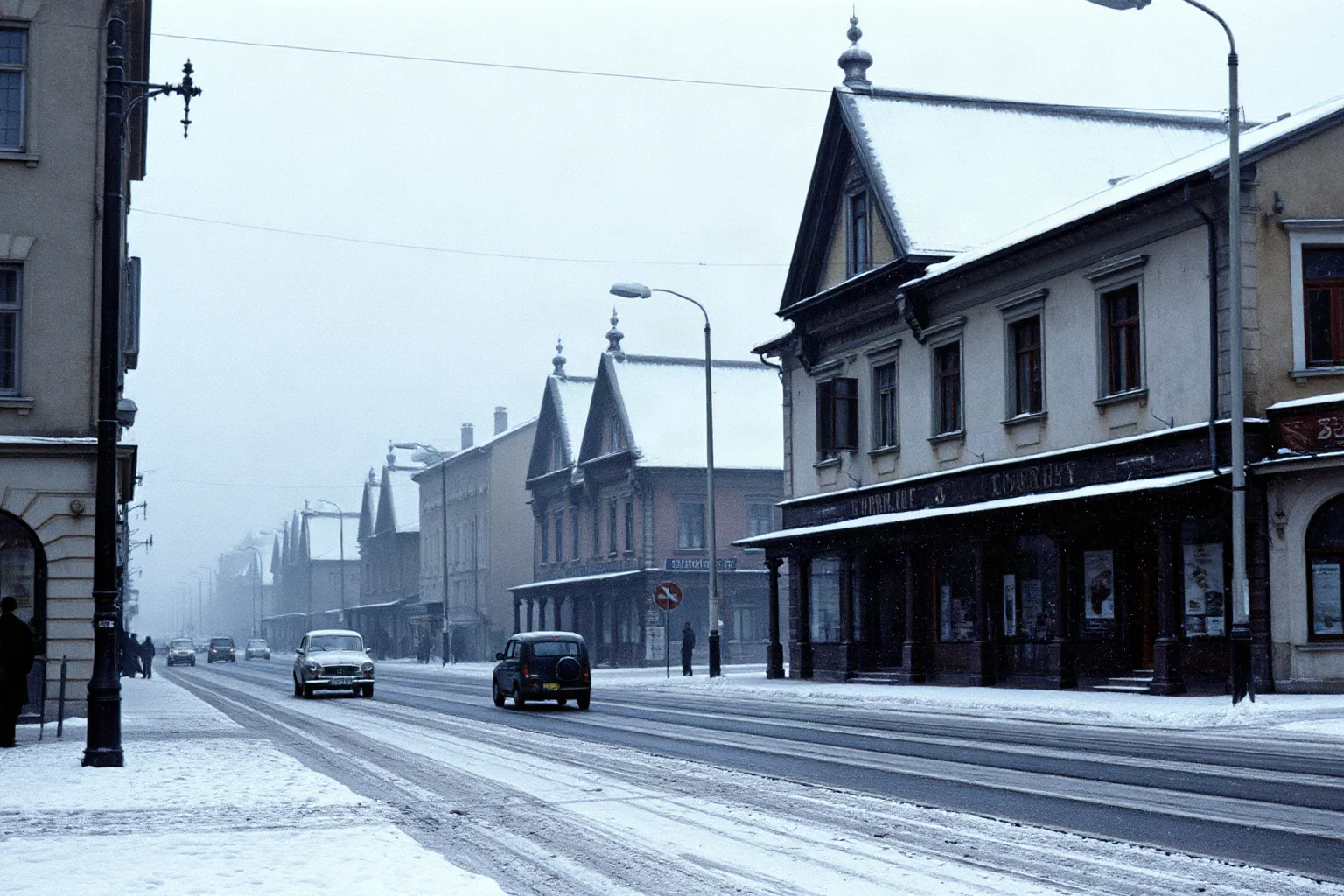A besieged World War II era city street in winter, snow falling on empty frozen streets