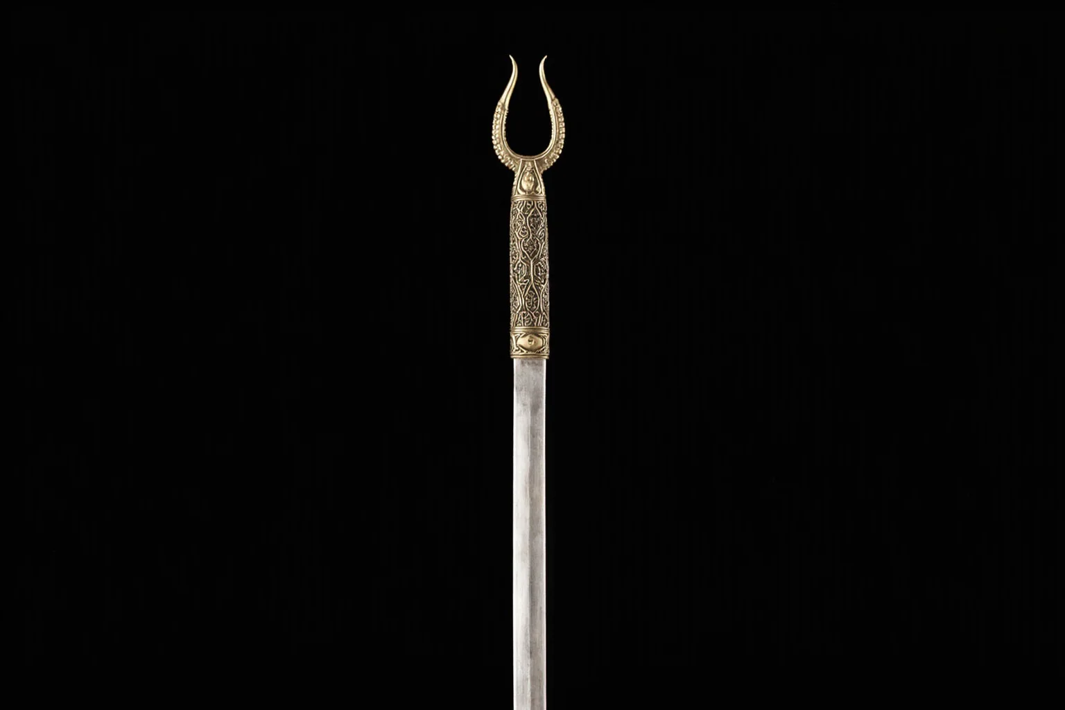 A ceremonial sword with a distinctive forked twin-pointed blade tip, ornamental Middle Eastern design