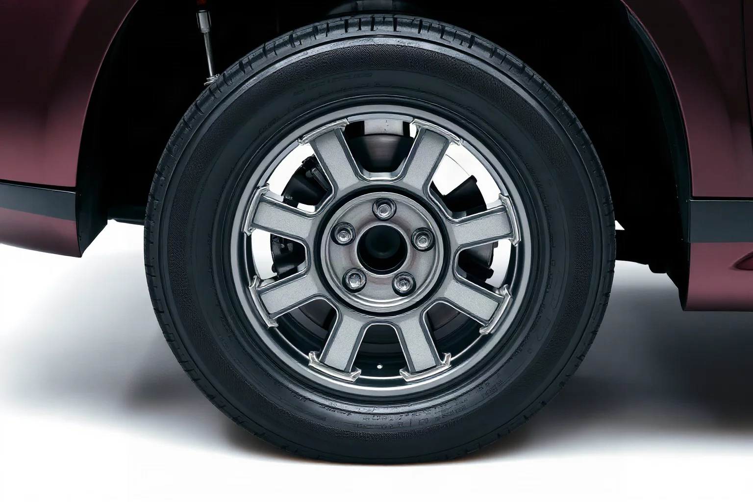 A close-up cutaway of a car tire showing radial steel-belt construction