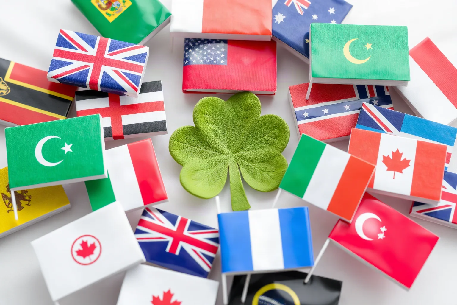 A collection of small flags from different countries around a shamrock, symbolizing global patronage