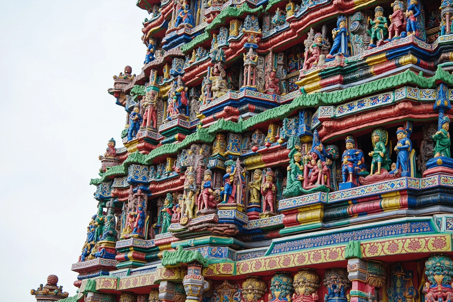 A colorful, intricately carved temple tower covered in painted sculptures