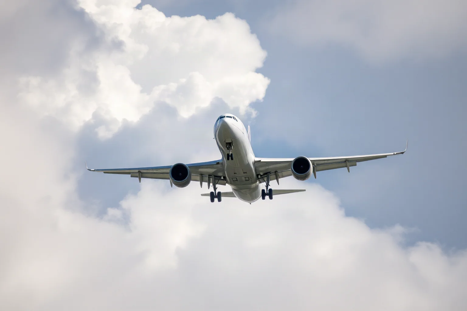 A commercial airliner descending through clouds with engines visibly powered down