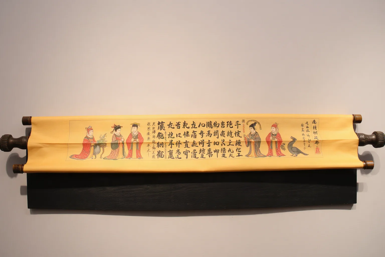 A decorative image of an ancient Japanese illustrated hand scroll with painted courtly figures and calligraphy-style flourishes, museum artifact aesthetic, no real text legible