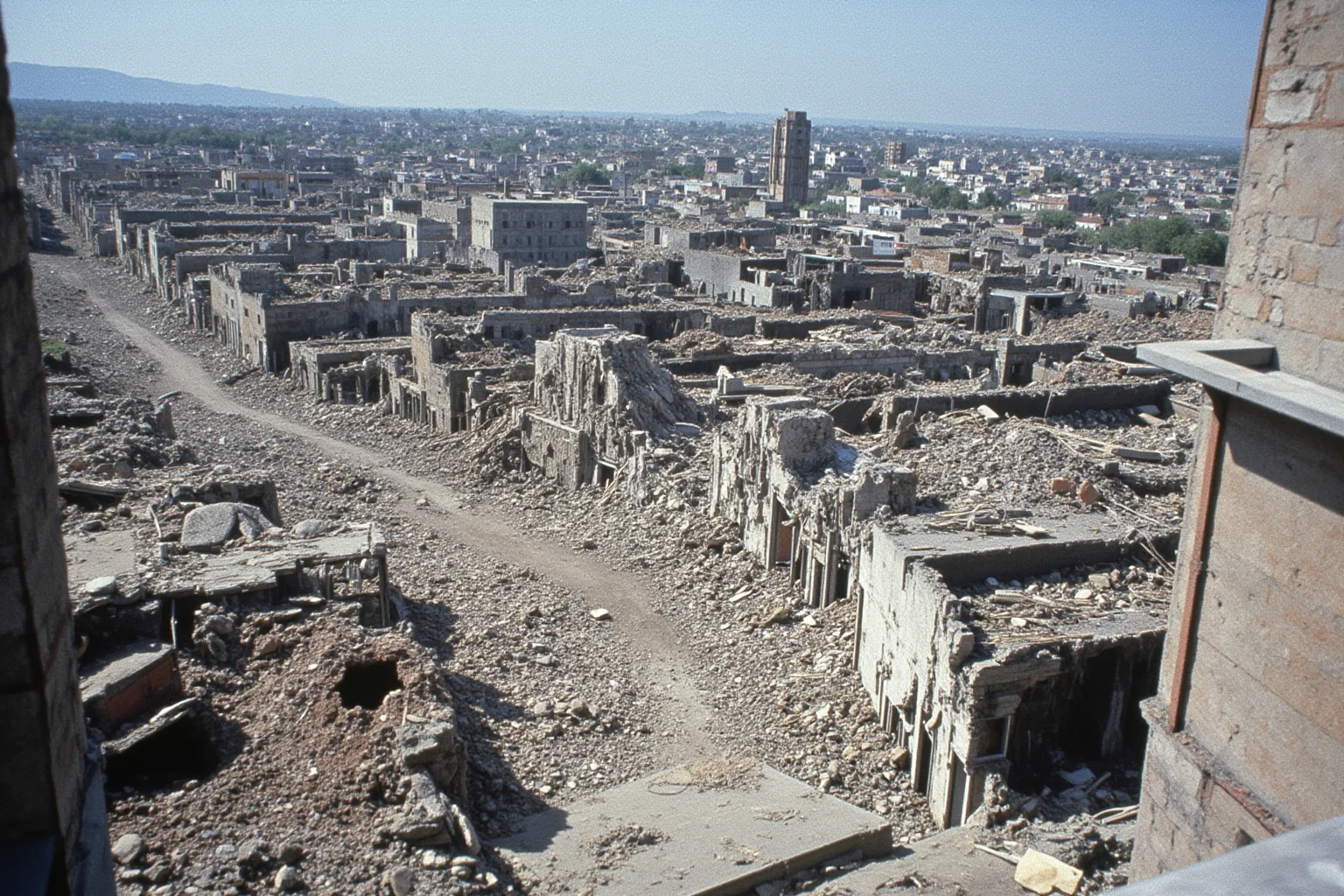 A devastated industrial city with collapsed buildings after a major earthquake, mid-20th-century style