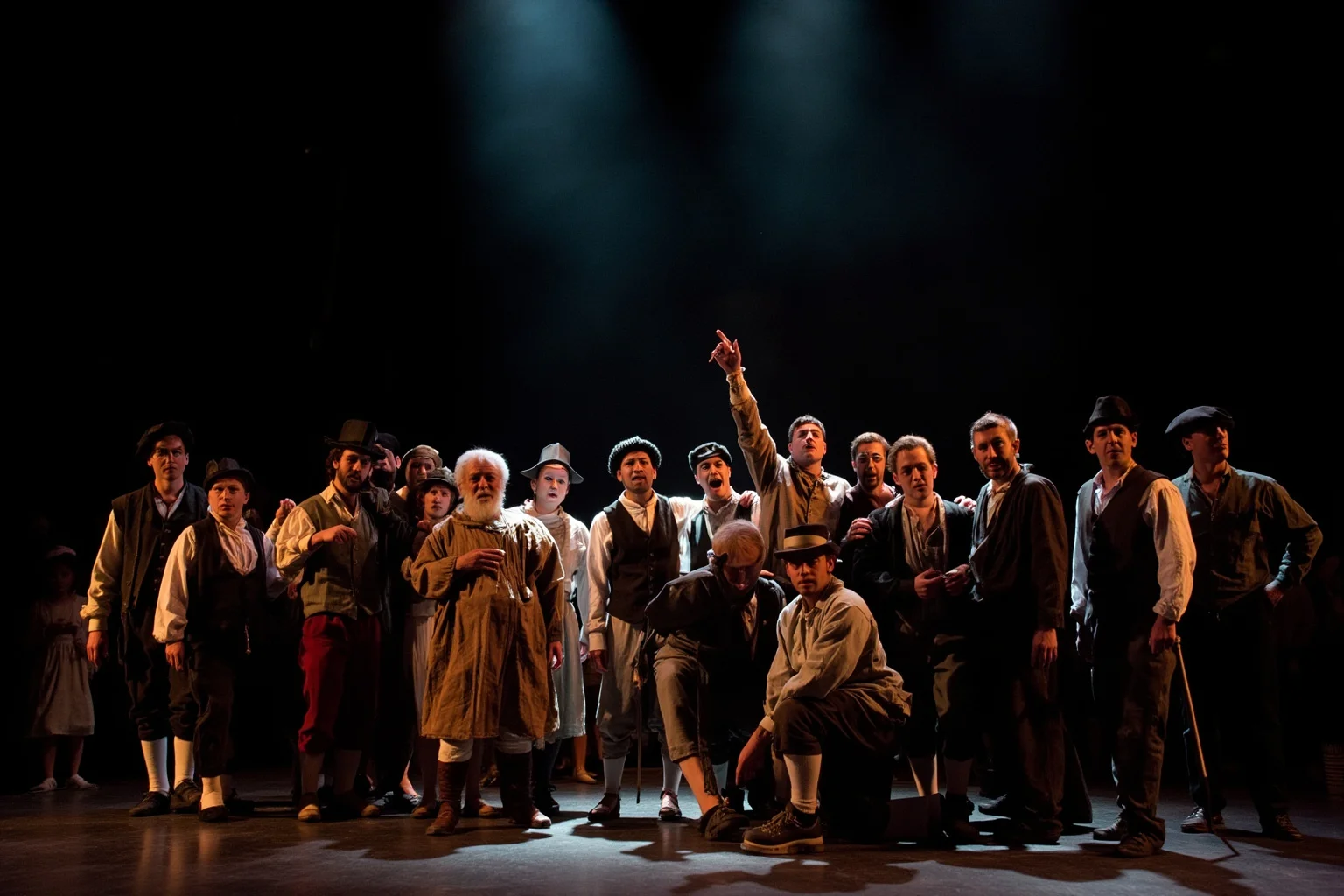 A diverse group of stage performers in colonial-style costumes standing together under dramatic stage lighting