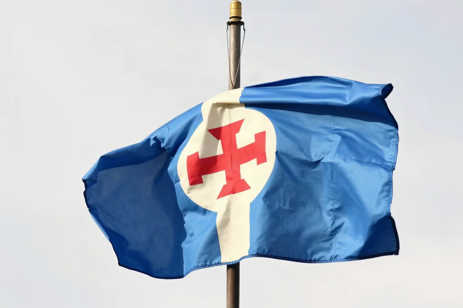 A faded blue heraldic flag fluttering on an old flagpole, symbolizing St. Patrick's original color