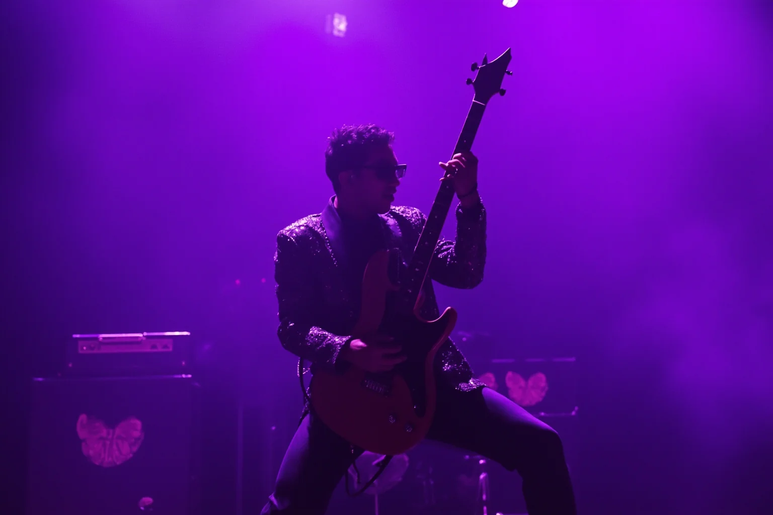 A flamboyant funk-rock guitarist performing an expressive solo under purple stage lighting, sequined jacket, dramatic pose