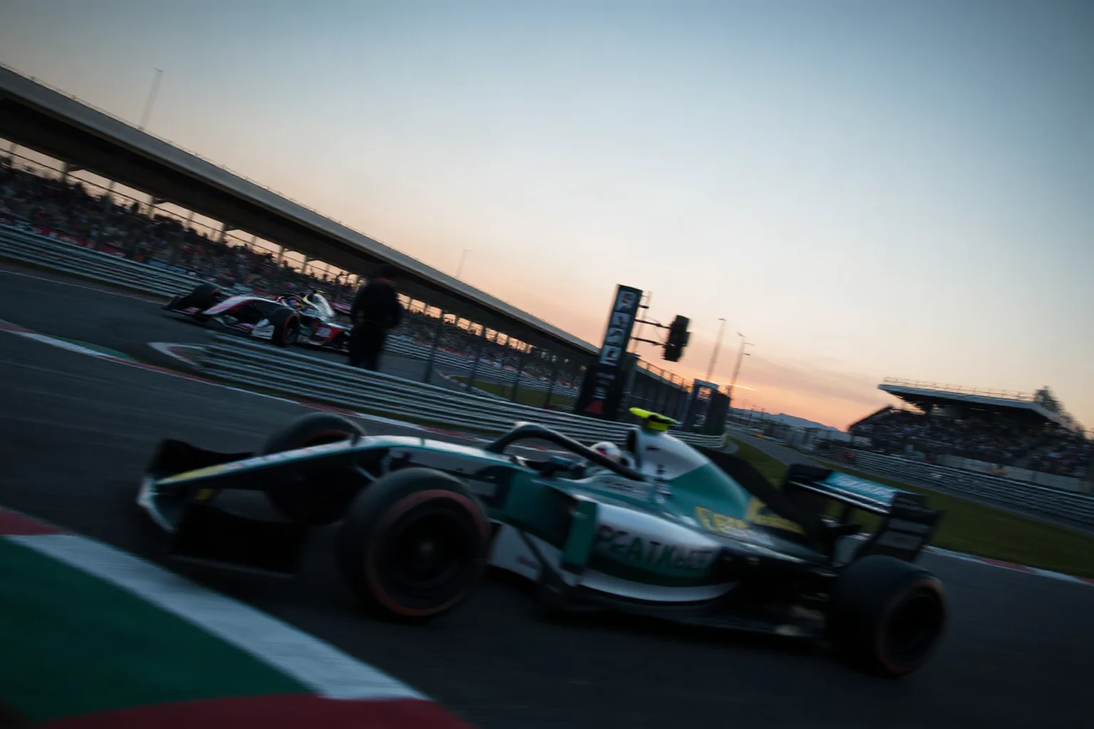A Formula 1 car racing through a chicane at a classic circuit, sunset lighting, cinematic motorsport atmosphere