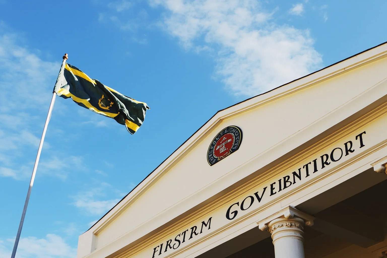 A government building facade with a tribal flag flying beside it, symbolizing tribal sovereignty