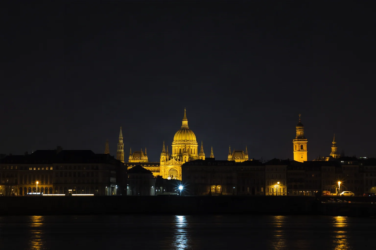 A grand burning skyline of a 17th-century European city viewed from across a river at night