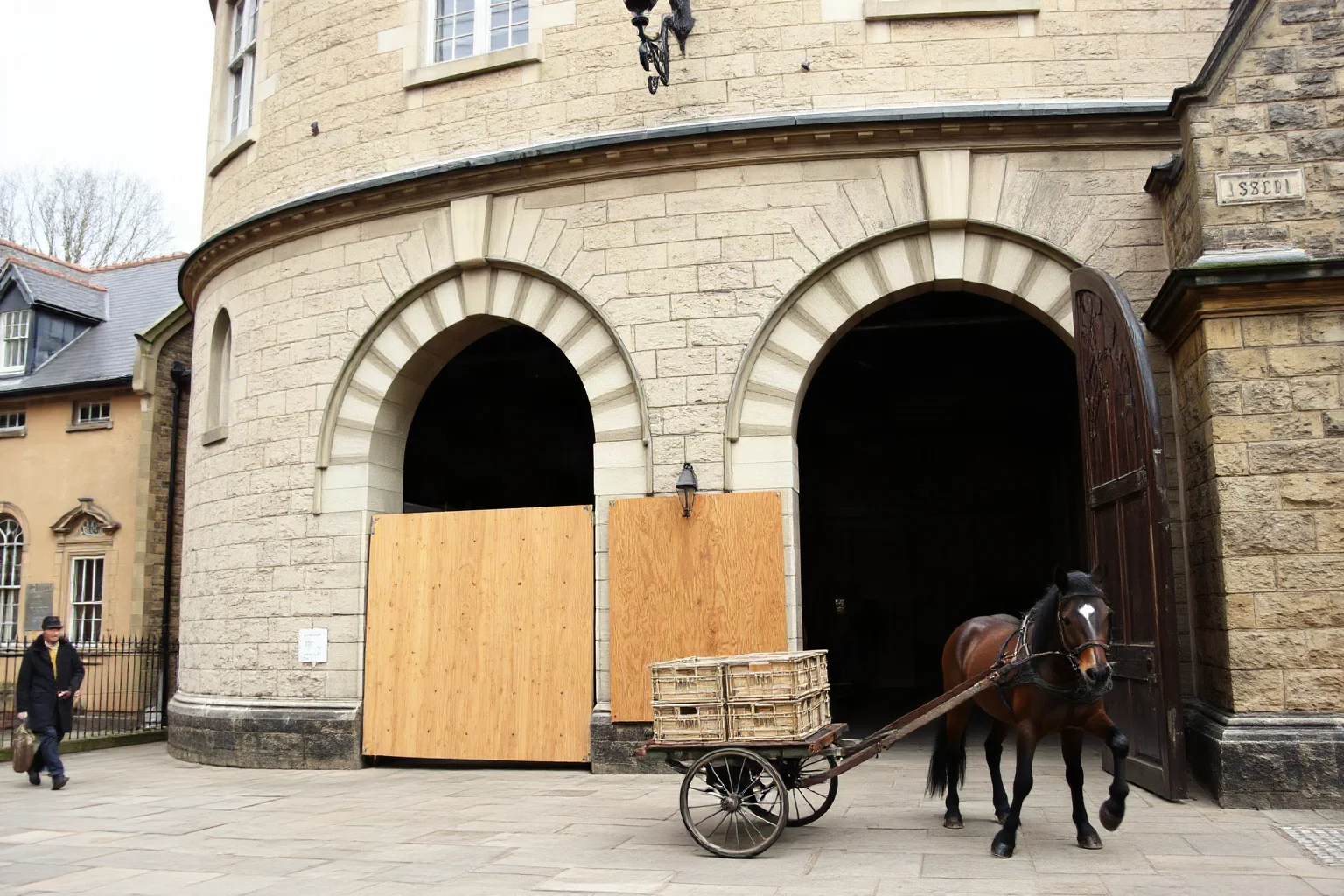 A grand stone tower entrance being boarded up, with empty animal cages and a horse-drawn cart loading crates, 1800s London style