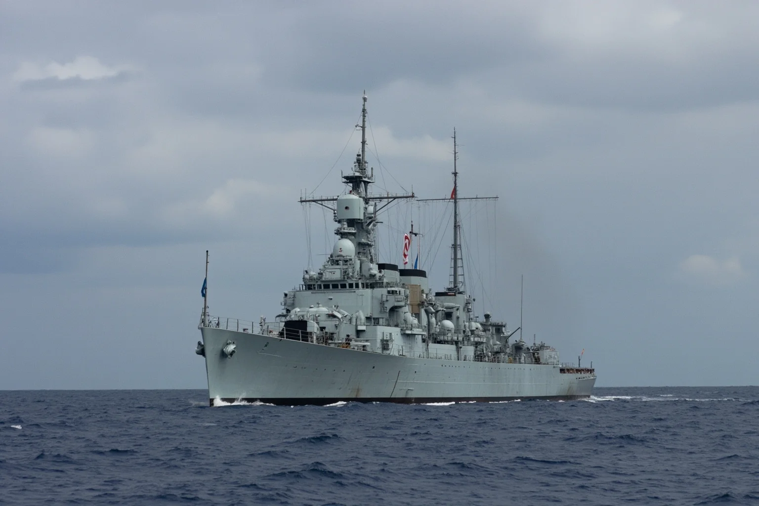 Memorable Moments Of Friendly Fire Throughout History 11 A gray naval vessel at sea under a tense sky, generic mid-20th-century warship illustration, no identifiable markings
