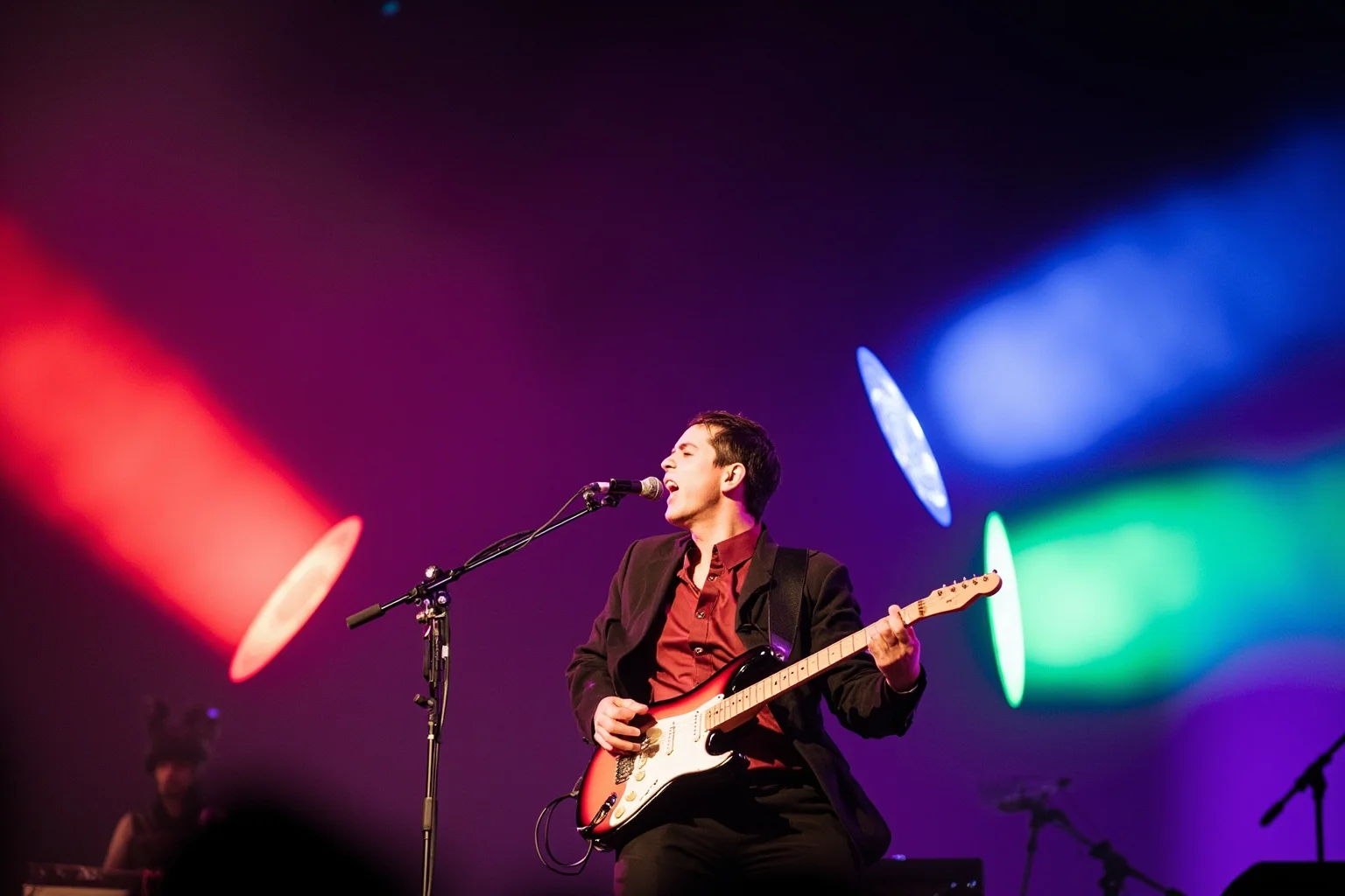 A guitarist blending Latin rhythm and rock, colorful festival stage, sustained note visualized as glowing sound waves