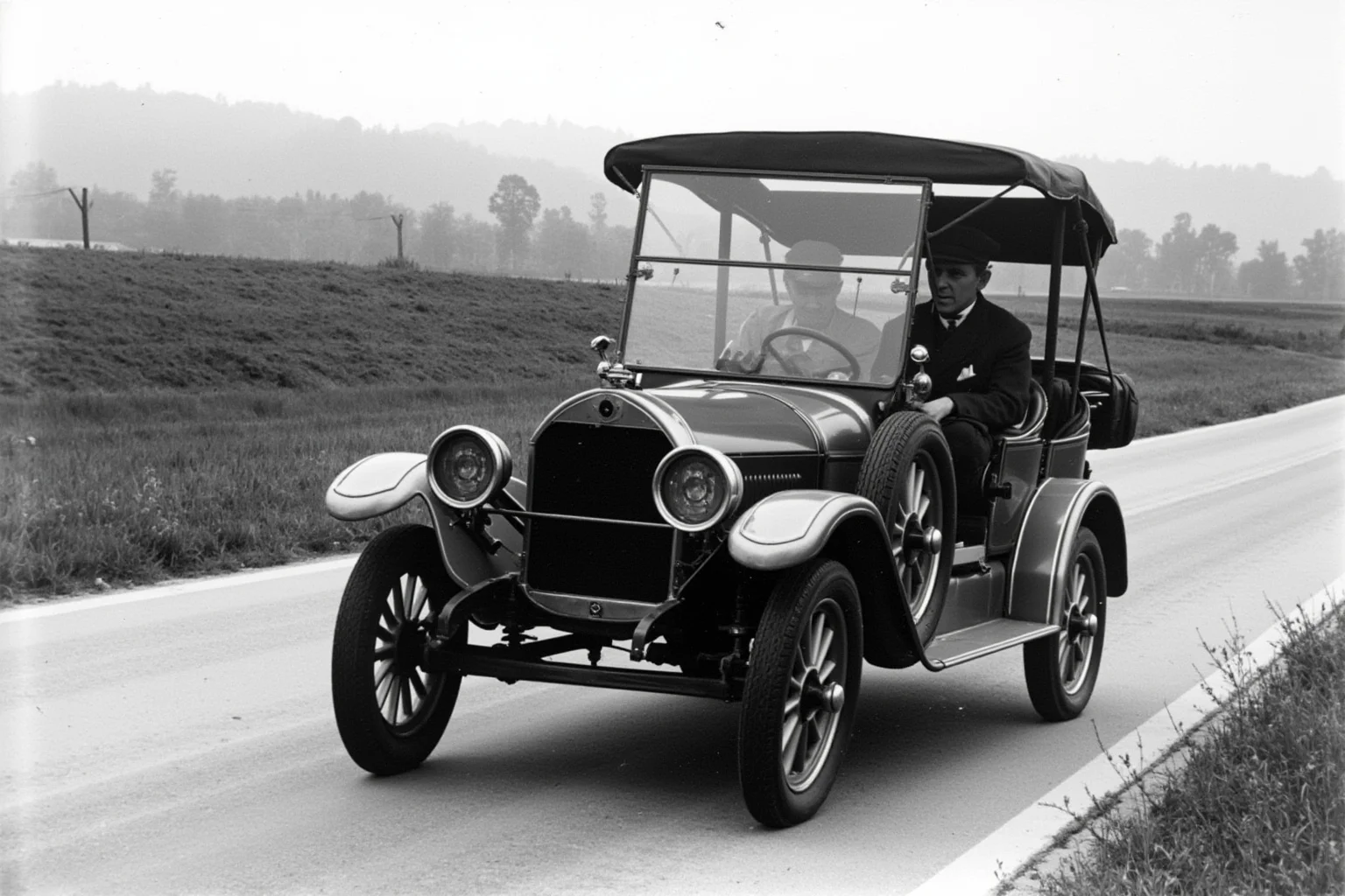 A late-1920s touring sedan with a folding windshield and rounded fenders on a rural American road