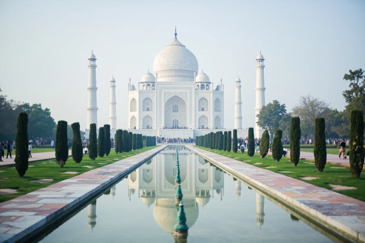 A long reflecting pool leading toward a grand white domed mausoleum, its image mirrored perfectly in the water