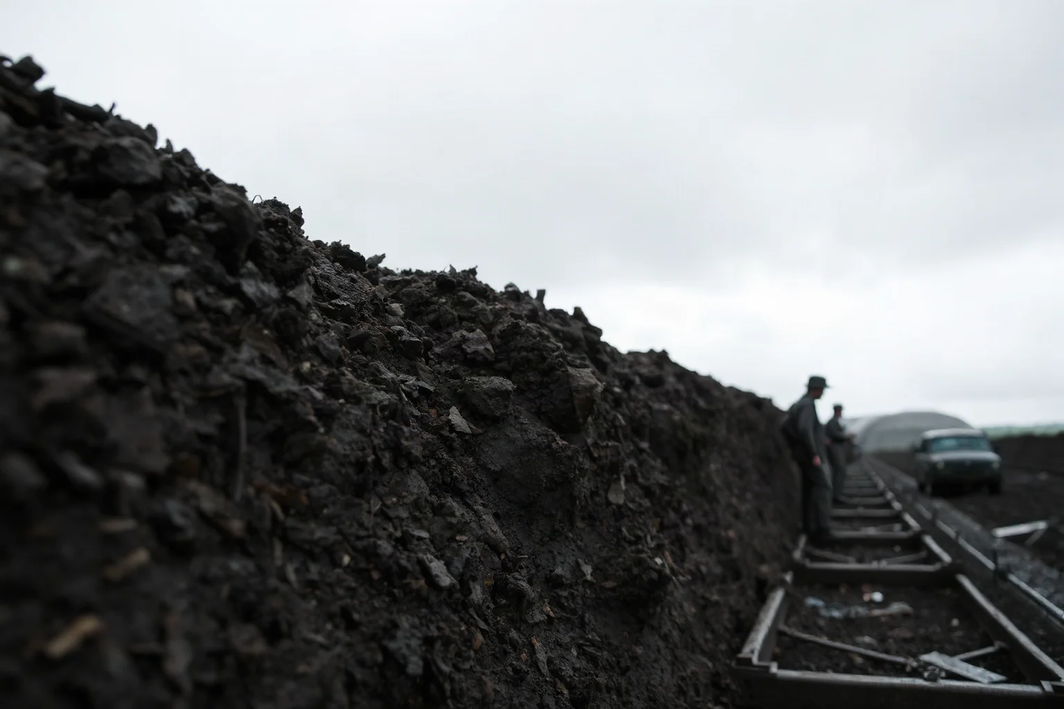 A muddy World War I era trench line under a grey overcast sky, no soldiers visible