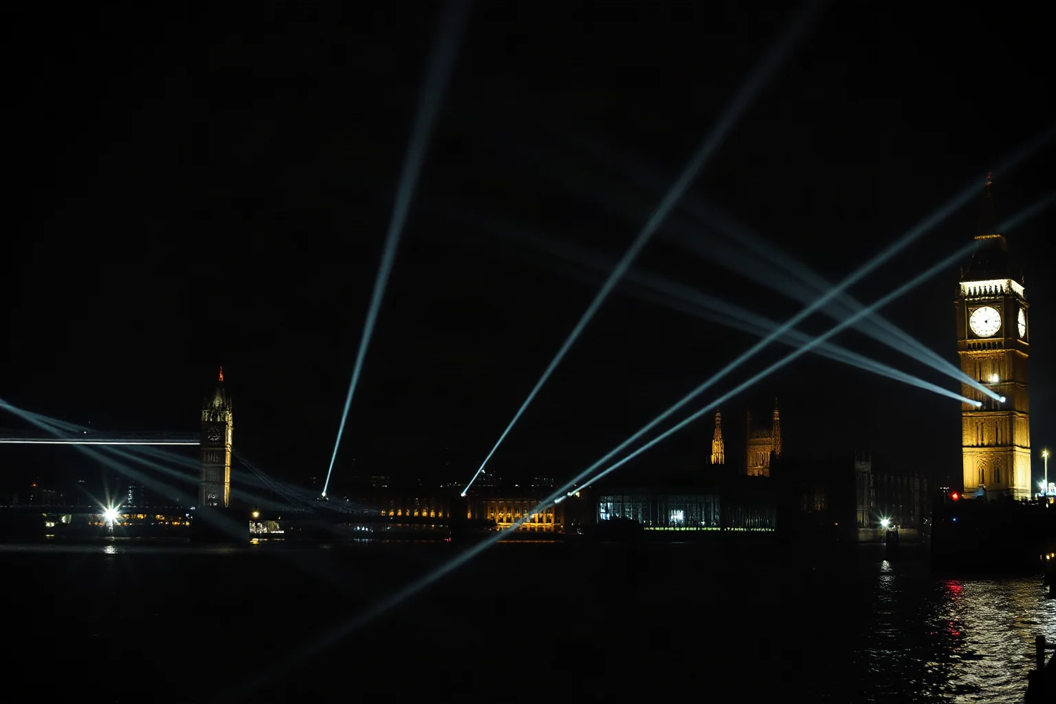 A nighttime London skyline silhouette crossed by searchlight beams during wartime blackout