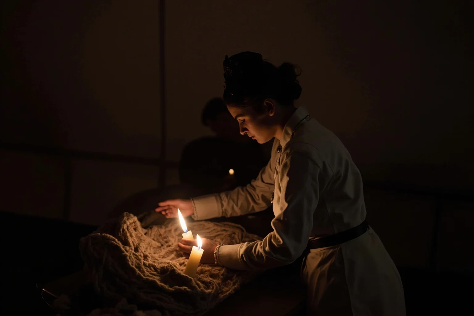 A nurse in a Victorian uniform tending to wounded soldiers in a dim candlelit field hospital tent