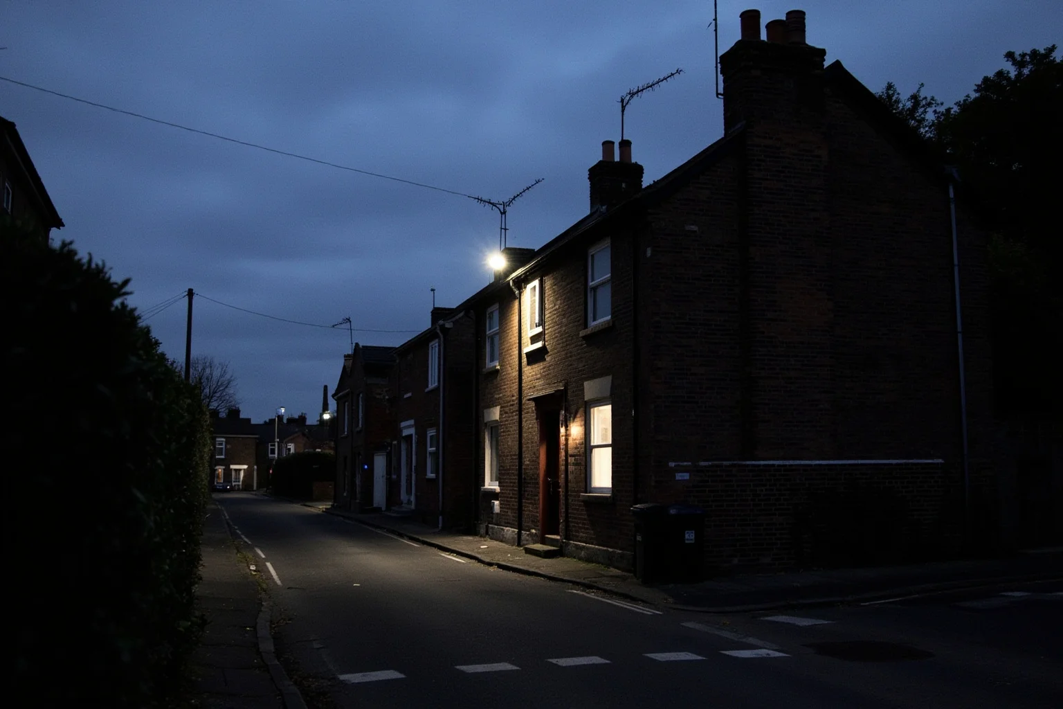 A quiet English seaside town street at dusk with a nondescript brick house, hinting at a hidden Cold War spy ring