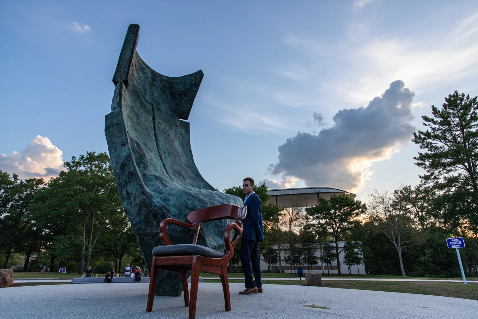 A raised ceremonial chair positioned on a stage beneath a towering abstract bronze sculpture