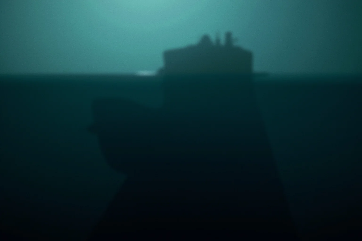 22 Ocean Mysteries We Still Haven't Solved 23 A shadowy submarine base silhouette hidden deep beneath the ocean surface, evoking speculative conspiracy imagery