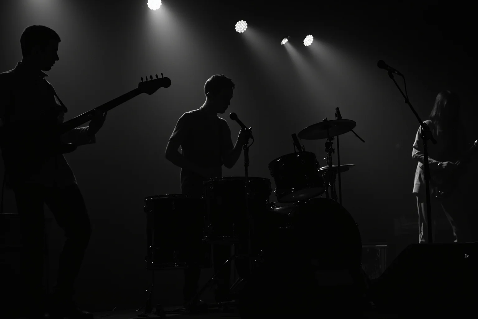 Incredible Facts About the Beatles' Greatest Band History 4 A silhouette of a drummer joining three other musicians on a dimly lit 1960s club stage