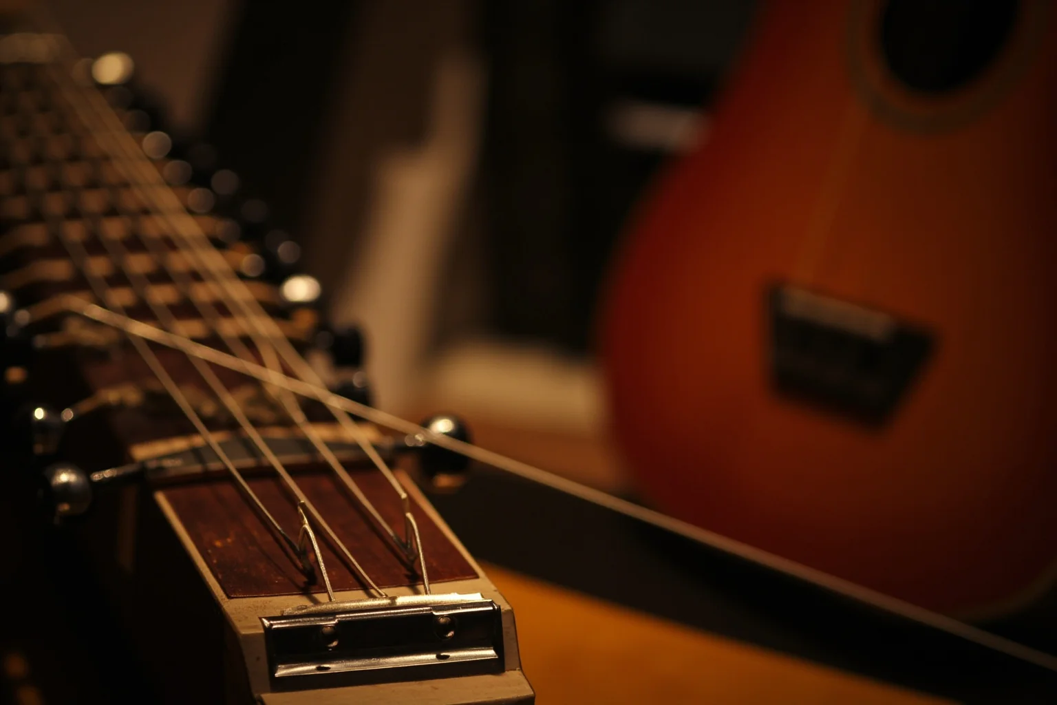 Incredible Facts About the Beatles' Greatest Band History 17 A sitar resting beside an electric guitar in a warmly lit studio, blending Eastern and Western instruments