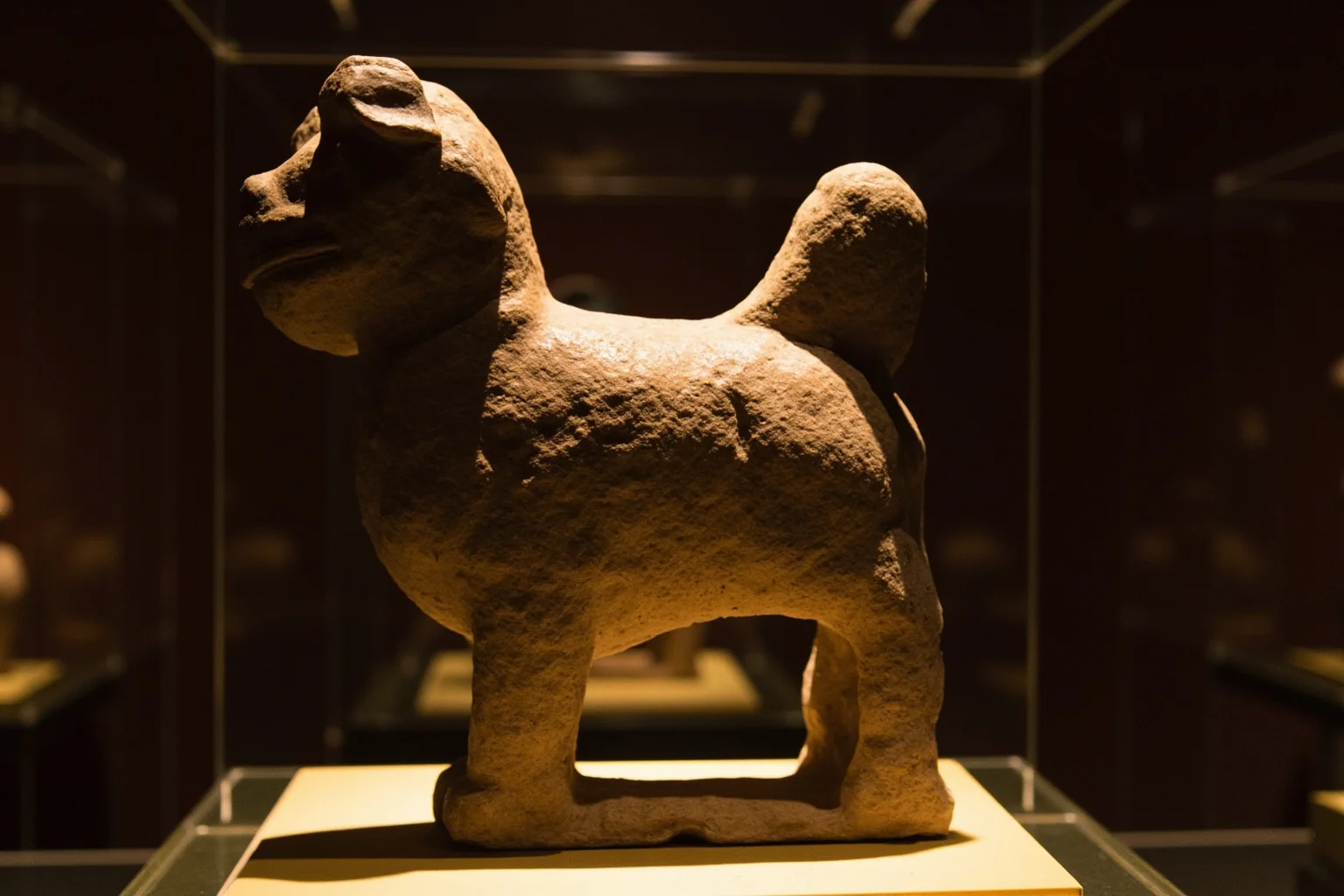 Pooches of the Past: 23 Extinct Dog Breeds and Their Stories 17 A small alert companion dog depicted in Aztec-style stone carving, museum artifact lighting