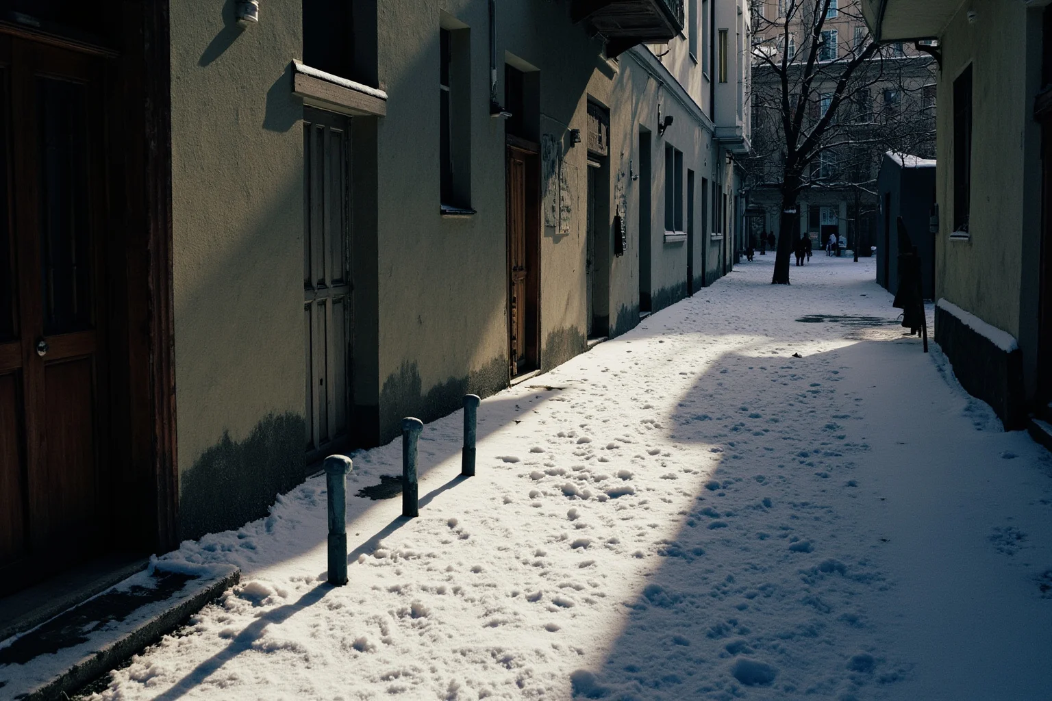 A snowy Russian urban alley with shadows suggesting stray dogs nearby, no people