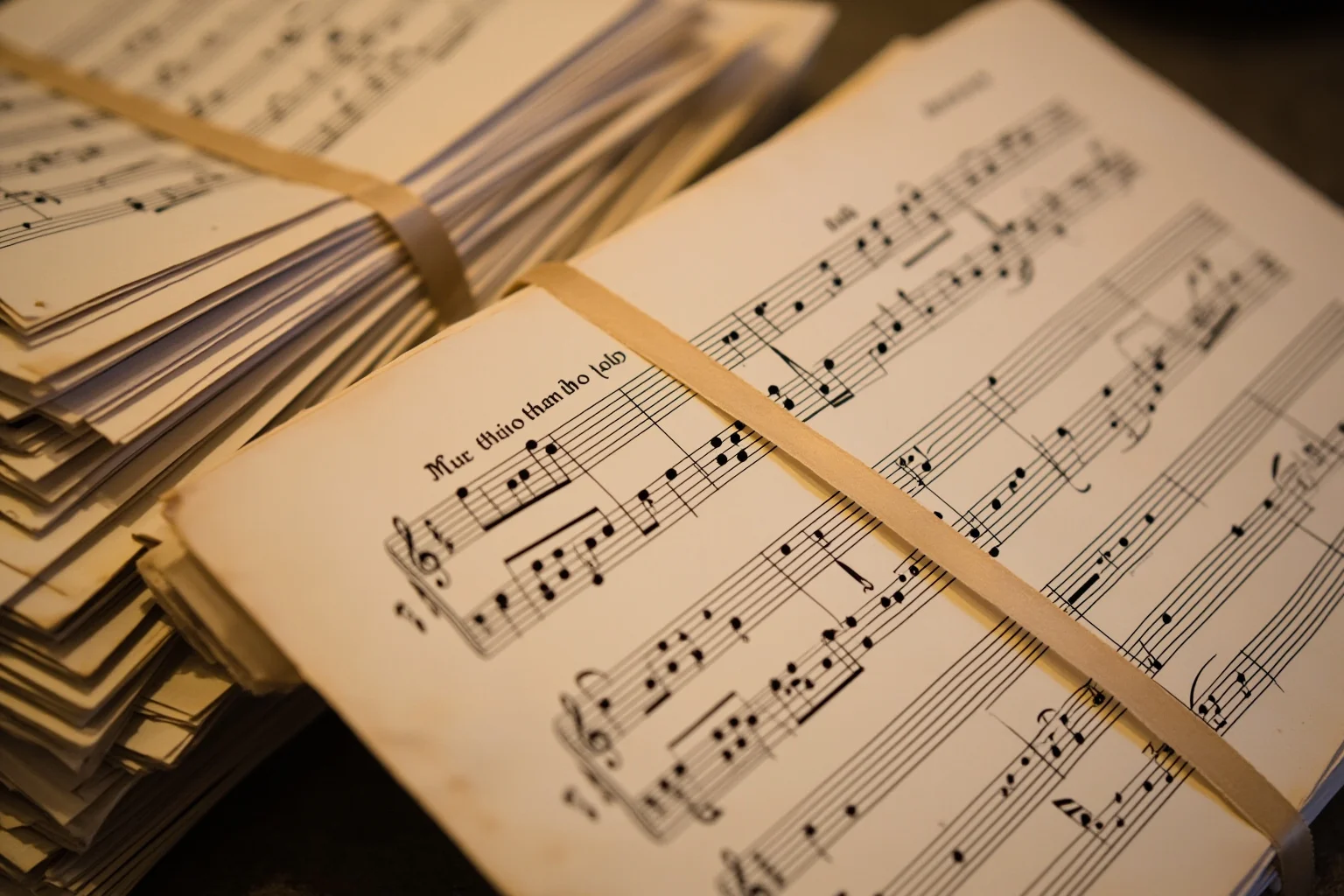 A stack of aged manuscript music sheets tied with ribbon, illustrating a large historical music catalog