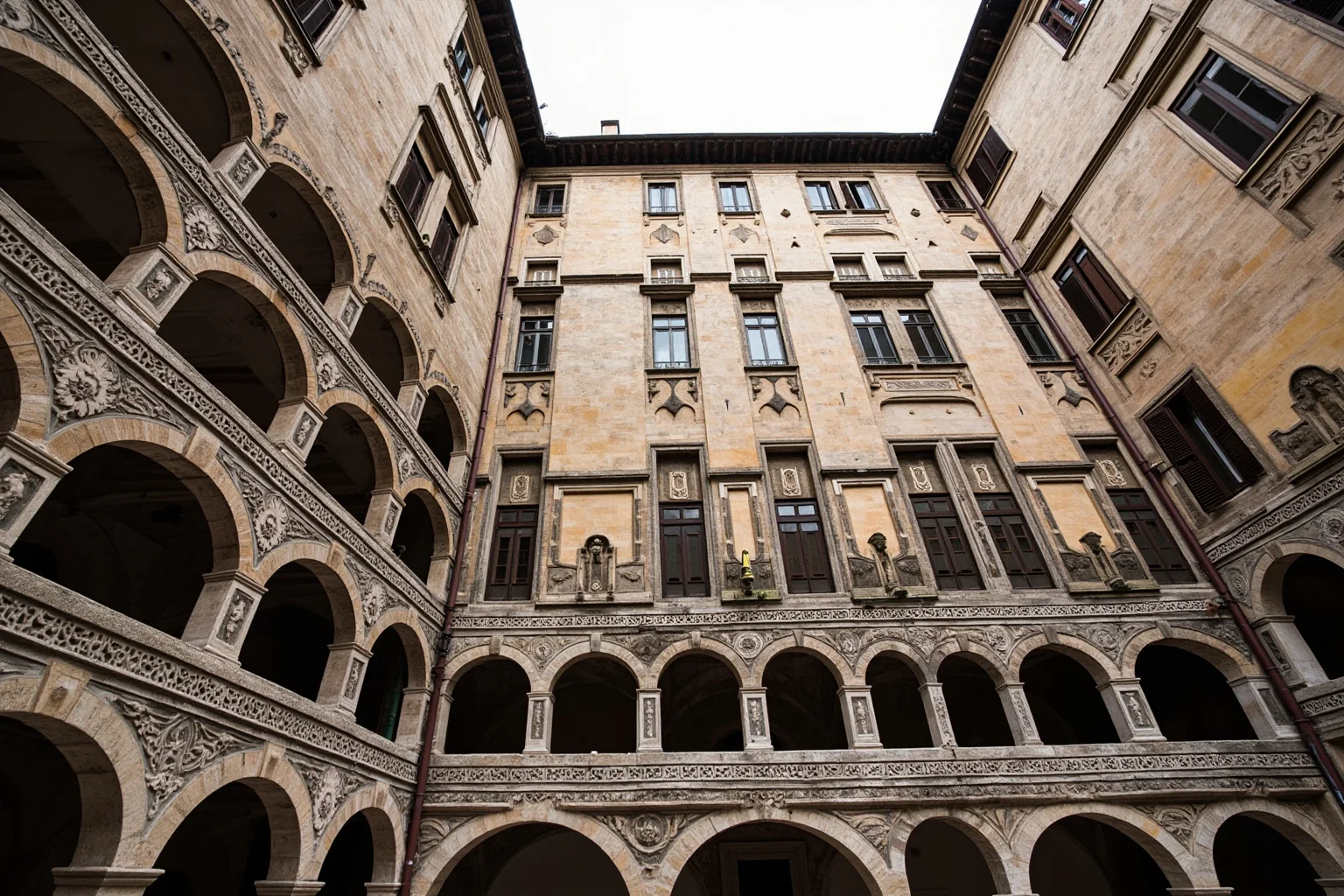 A stately Renaissance city palazzo with rusticated stone lower floor and smooth upper stories around a courtyard