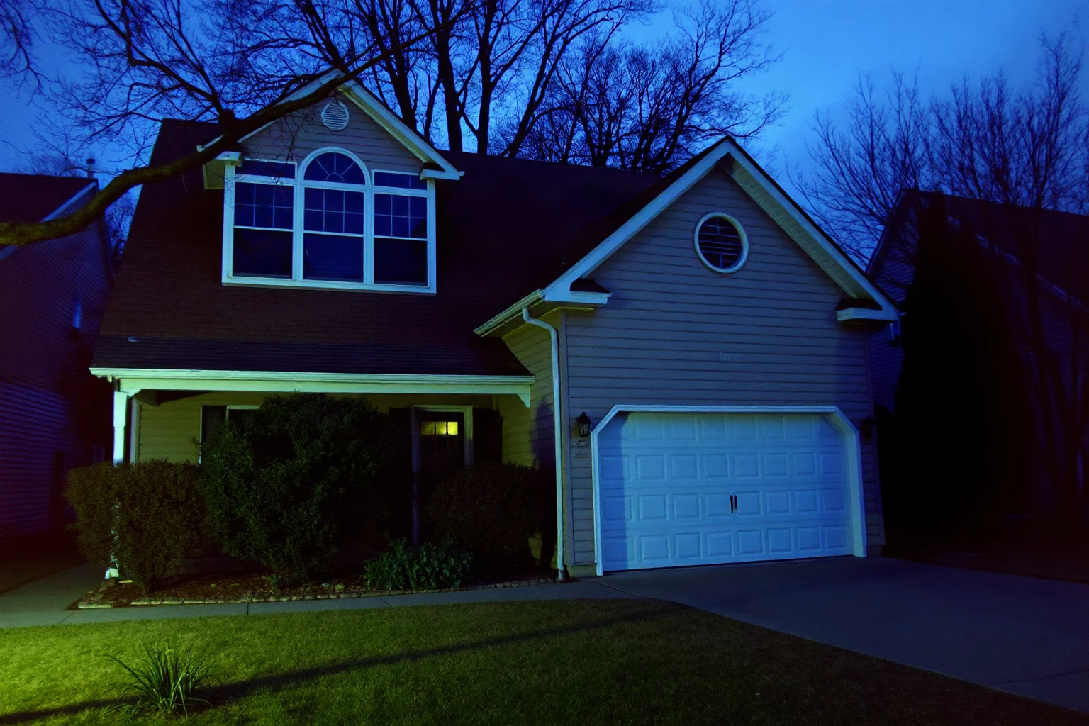 A suburban 1970s American house exterior with dark upper windows, eerie stillness