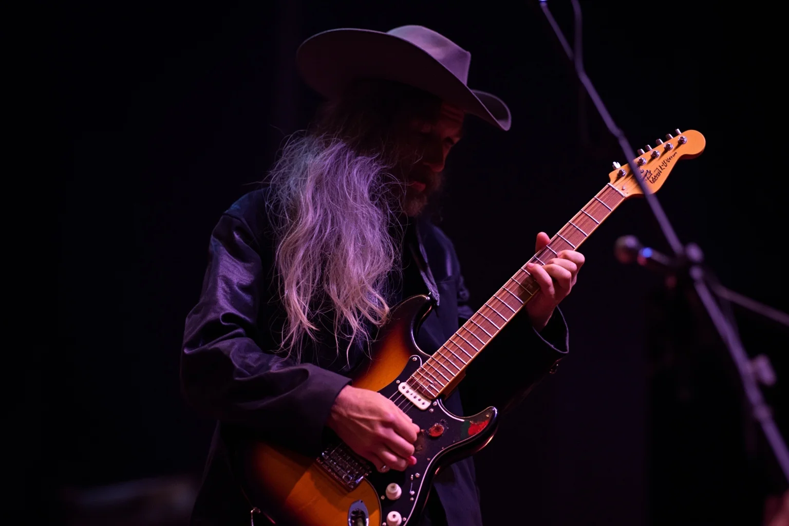 A Texas blues guitarist with a heavy-gauge string electric guitar, intense expression, gritty club stage atmosphere