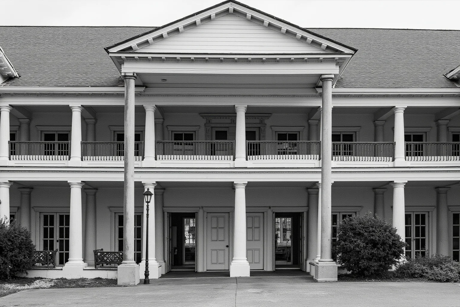 A two-story loggia facade with Doric columns below and Ionic columns above opening onto a town square