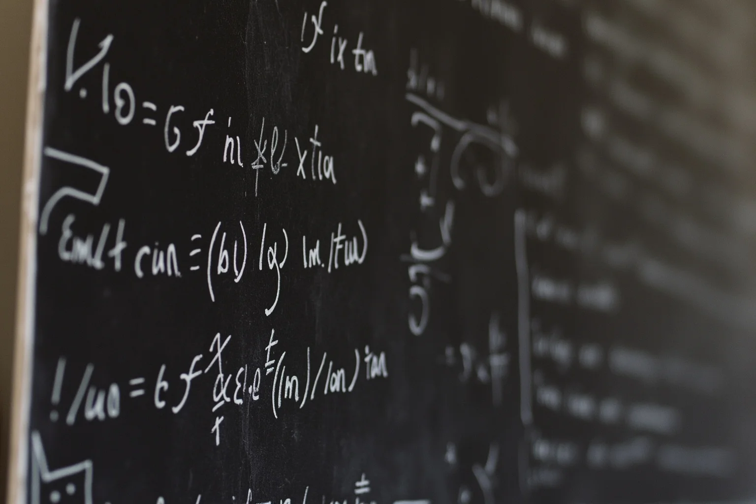 A vintage chalkboard covered in mathematical equations in an old European schoolroom setting