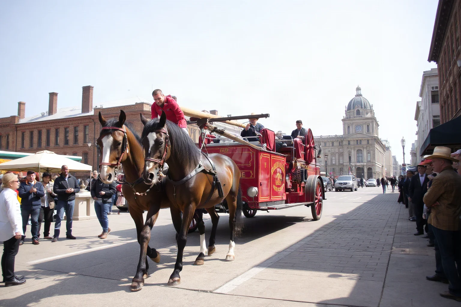 A vintage red fire truck with horses pulling it down an early 1900s city street, onlookers pointing