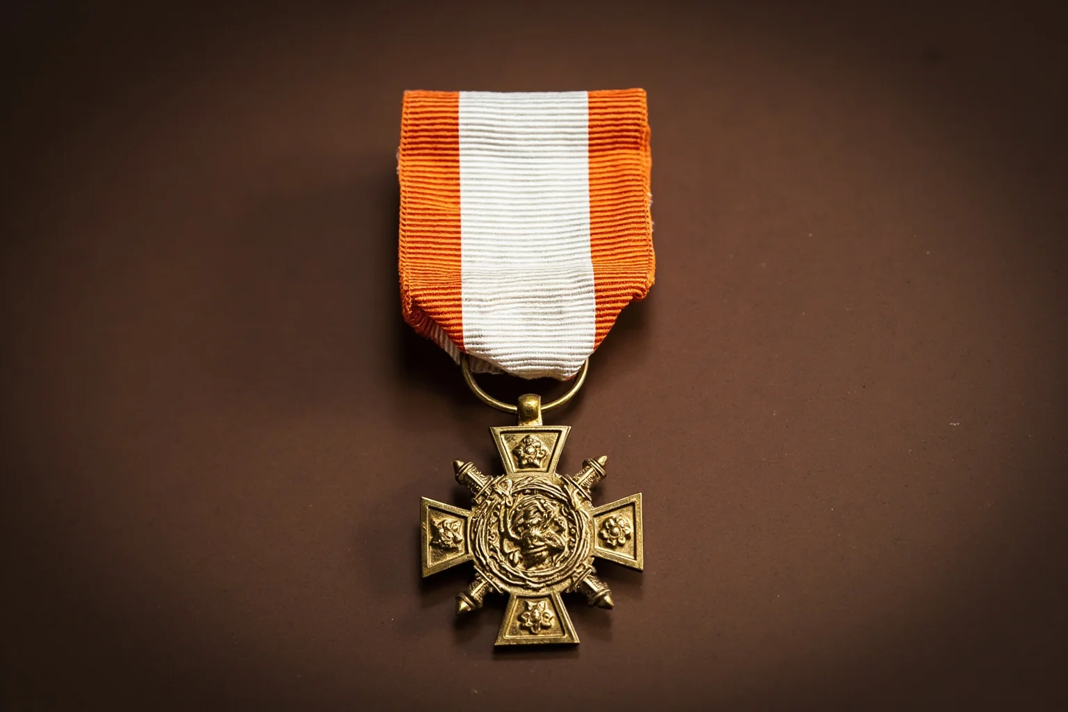 Highest Military Decorations: 20 Rare and Obsolete Medals You'll Never See Again 7 A white-and-orange striped ribbon holding an ornate gold cross medal, evoking an imperial-era European military honor