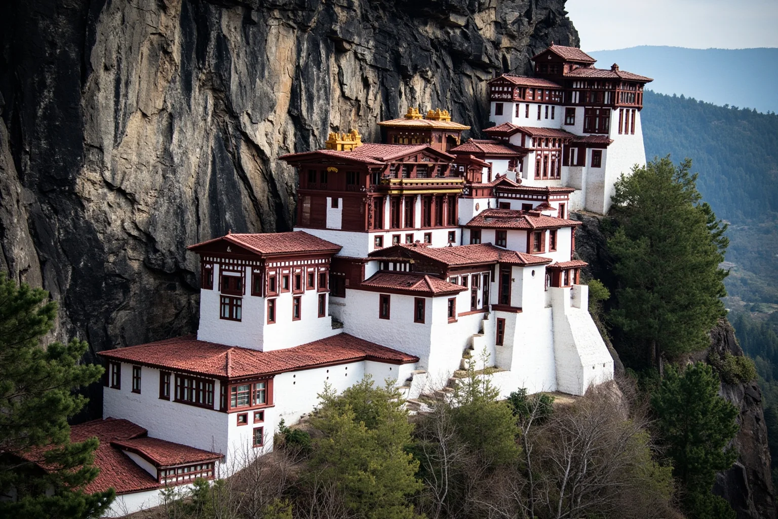 A white and red fortress-palace built into a steep hillside