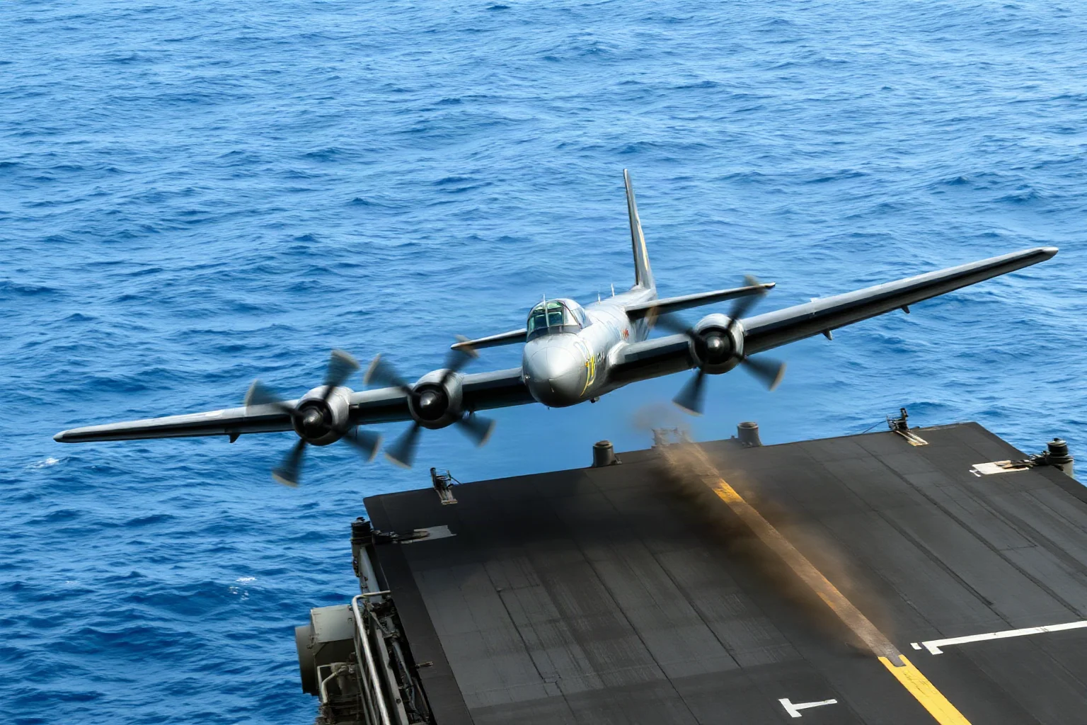 A World War II era bomber aircraft taking off from an aircraft carrier deck at sea