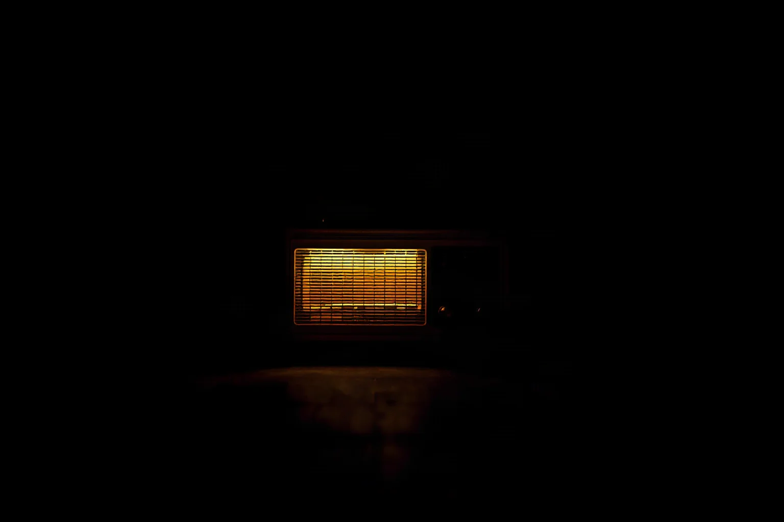 A worn spy-era radio set glowing softly in an otherwise empty dark room, cinematic lighting