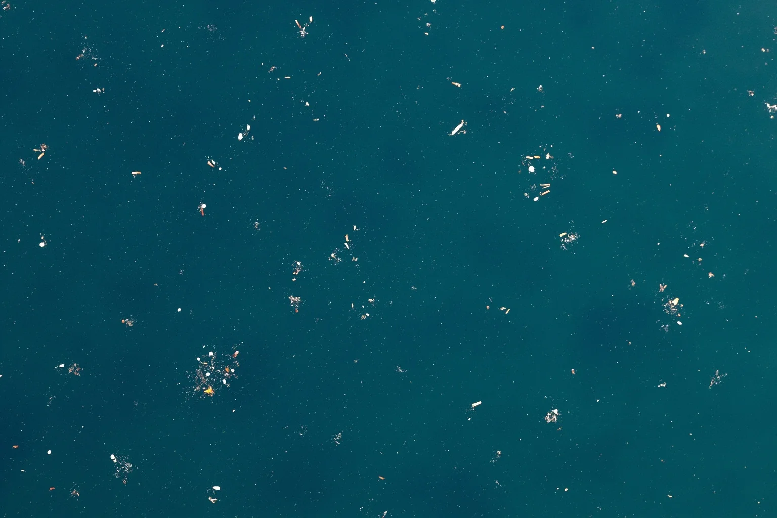 22 Ocean Mysteries We Still Haven't Solved 18 Aerial view of scattered plastic debris and microplastic fragments floating on the ocean surface
