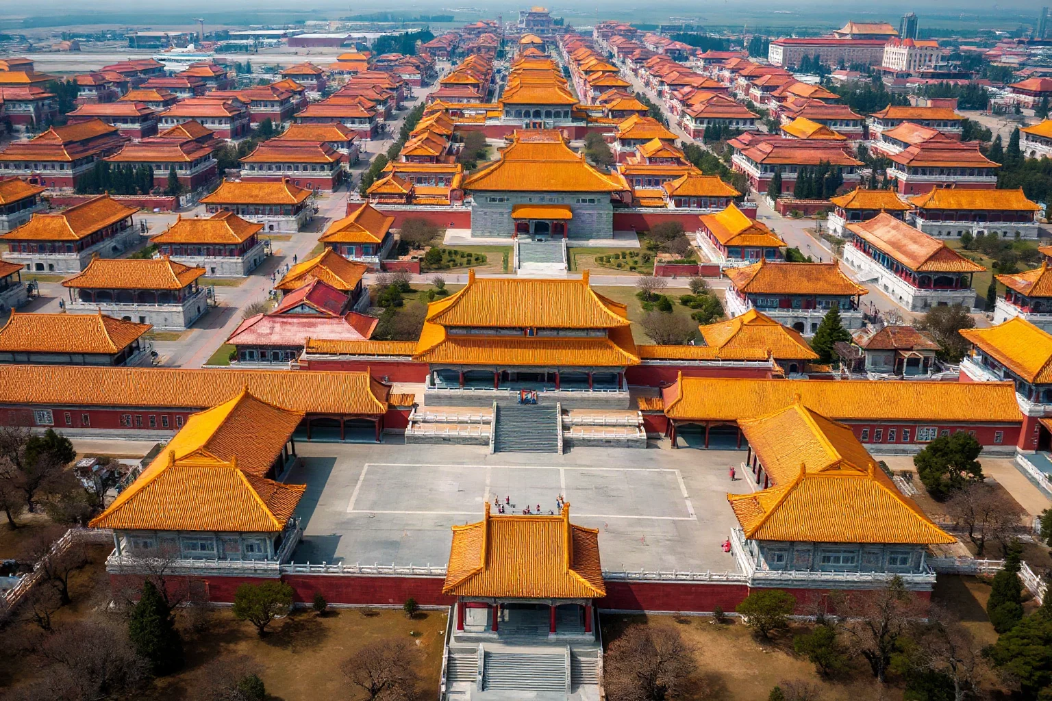 Aerial view of the Forbidden City in Beijing showing the vast complex of traditional Chinese palace buildings with golden roofs arranged in symmetrical courtyards