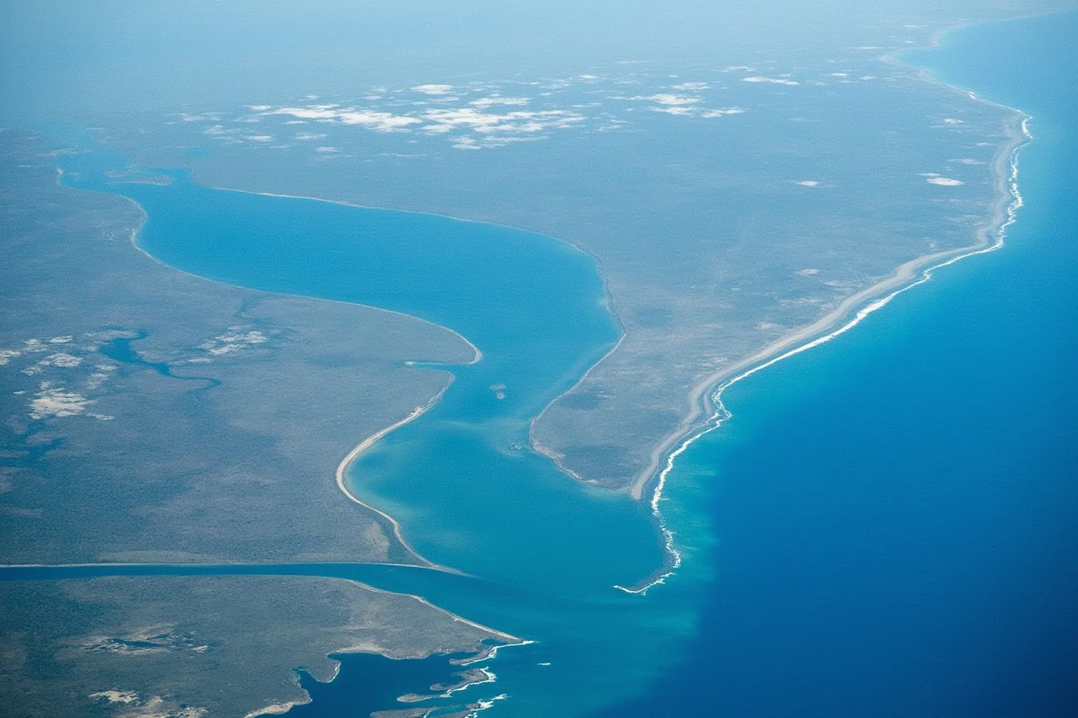 An aerial illustration of a narrowing bay shape funneling ocean water toward a river delta