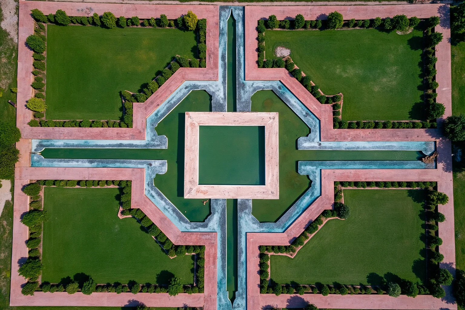 An aerial view of a symmetrical quartered Mughal garden with four water channels meeting at a central pool