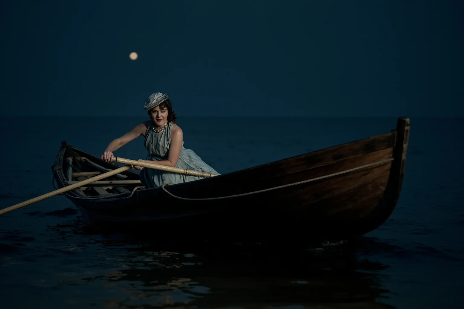 Historical Figures Who Boarded the Titanic — And 10 Who Didn't Survive 6 An elegant noblewoman in Edwardian dress helping row a wooden lifeboat at night on a calm dark sea