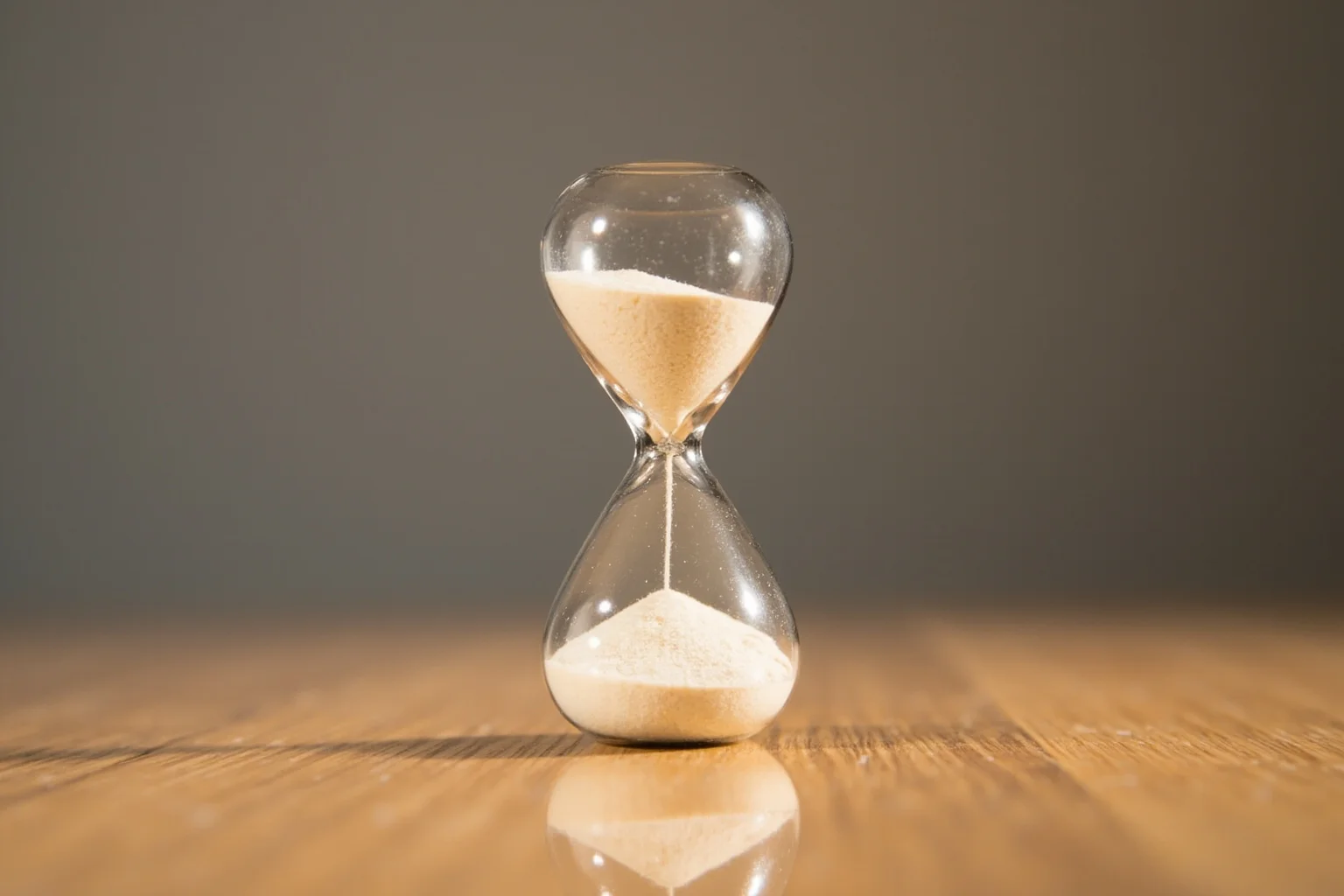 An hourglass with sand paused halfway, symbolizing a study cut short before its planned end