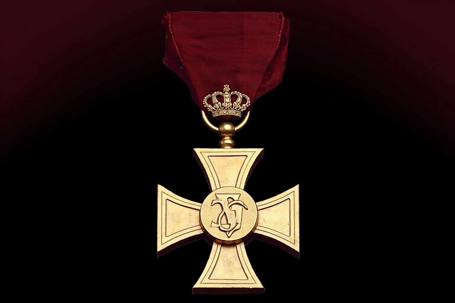 Highest Military Decorations: 20 Rare and Obsolete Medals You'll Never See Again 3 An illustration of a bronze cross-shaped medal on a dark red ribbon with a small crown detail, symbolizing a Commonwealth-style valor decoration