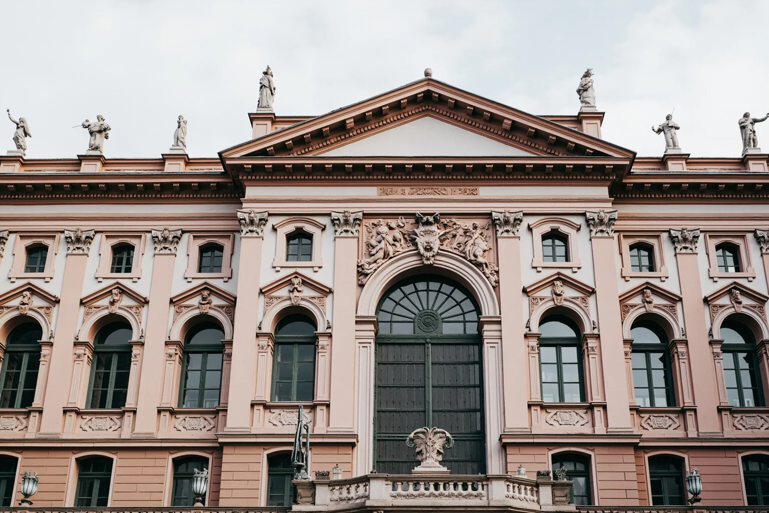 An imposing Renaissance palace facade in Rome with a bold sculptural cornice and tall arched windows